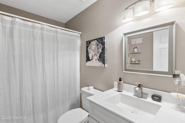 bathroom with vanity, a textured ceiling, and toilet