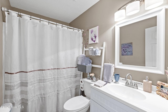 bathroom with vanity, toilet, and a textured ceiling