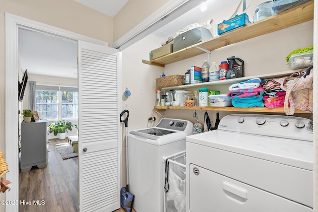 laundry room with hardwood / wood-style flooring and washer and clothes dryer