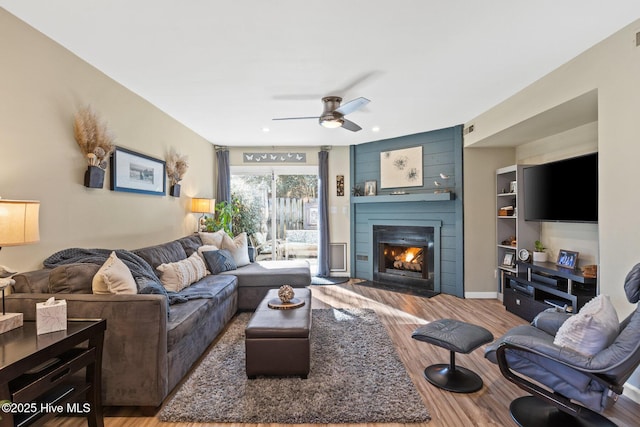 living room with ceiling fan, hardwood / wood-style floors, and a fireplace