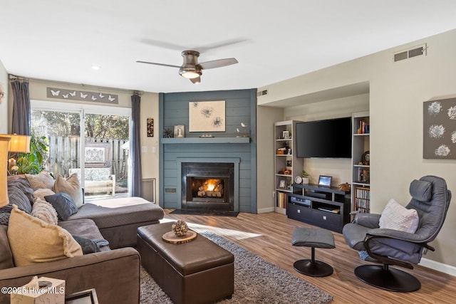 living room featuring hardwood / wood-style flooring, a fireplace, and ceiling fan