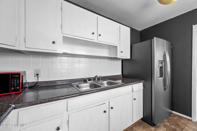 kitchen with white cabinets, stainless steel refrigerator with ice dispenser, backsplash, and sink