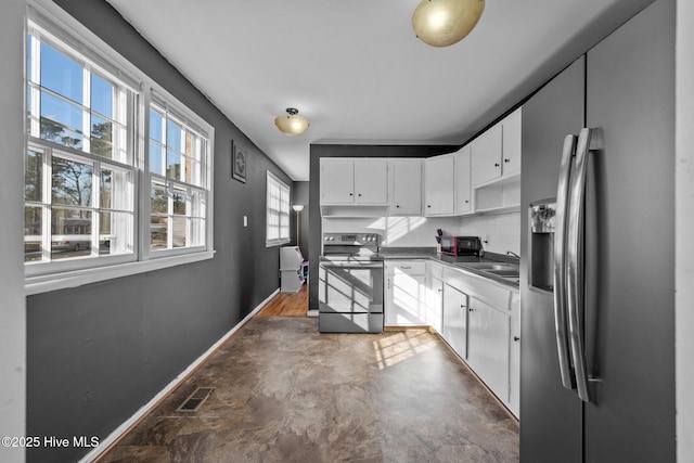 kitchen with appliances with stainless steel finishes, white cabinets, and sink