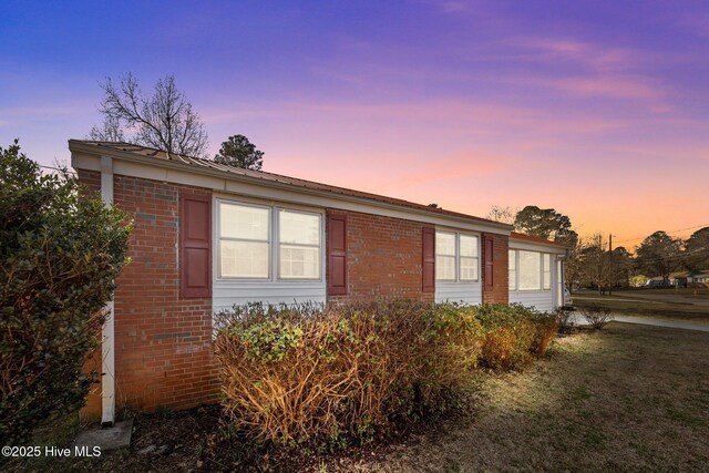 view of front of property featuring a front yard and a sunroom