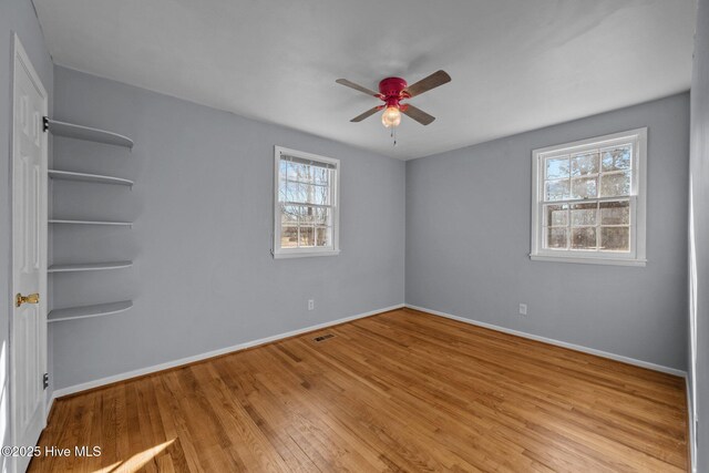 unfurnished room featuring ceiling fan, light wood-type flooring, and plenty of natural light