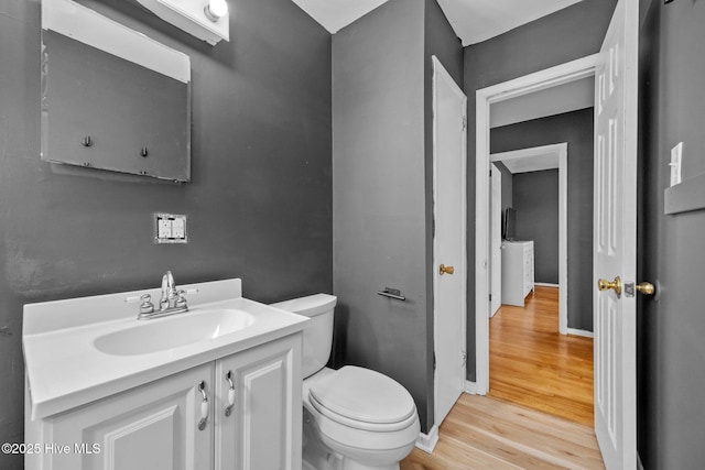 bathroom with toilet, wood-type flooring, and vanity