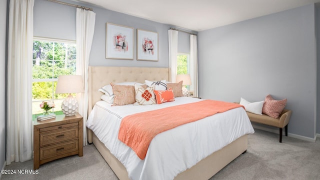 bedroom featuring light carpet and multiple windows