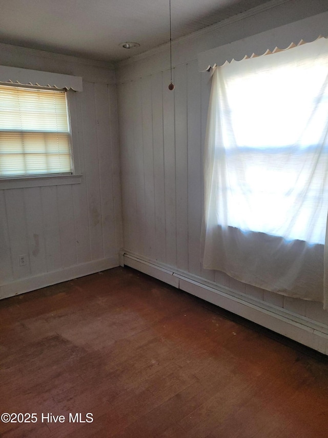 spare room featuring a baseboard radiator and dark hardwood / wood-style flooring