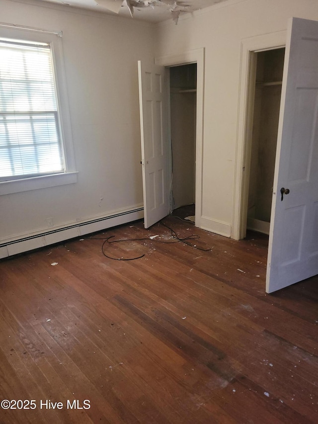 unfurnished bedroom with a baseboard radiator and dark hardwood / wood-style flooring