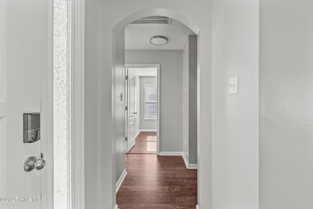 hall with dark hardwood / wood-style floors and a textured ceiling