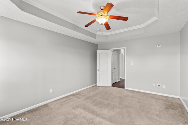 carpeted empty room with crown molding, a textured ceiling, a raised ceiling, and ceiling fan