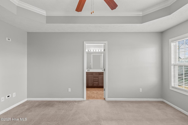 carpeted spare room with crown molding, a raised ceiling, and ceiling fan