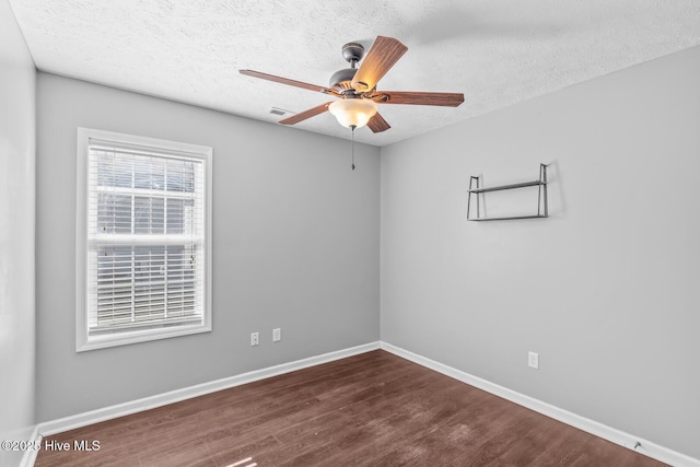 unfurnished room with ceiling fan, dark hardwood / wood-style floors, and a textured ceiling