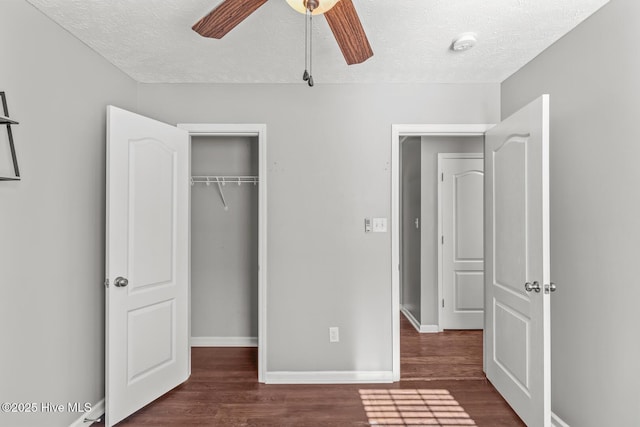 unfurnished bedroom featuring ceiling fan, dark hardwood / wood-style flooring, a closet, and a textured ceiling