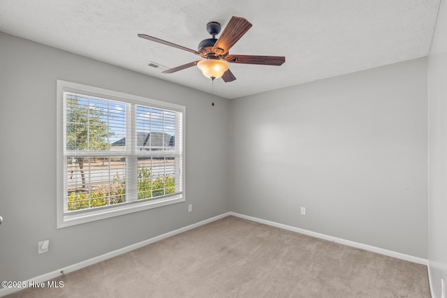 unfurnished room featuring light carpet, a textured ceiling, and ceiling fan