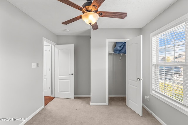 unfurnished bedroom with light carpet, a closet, and ceiling fan