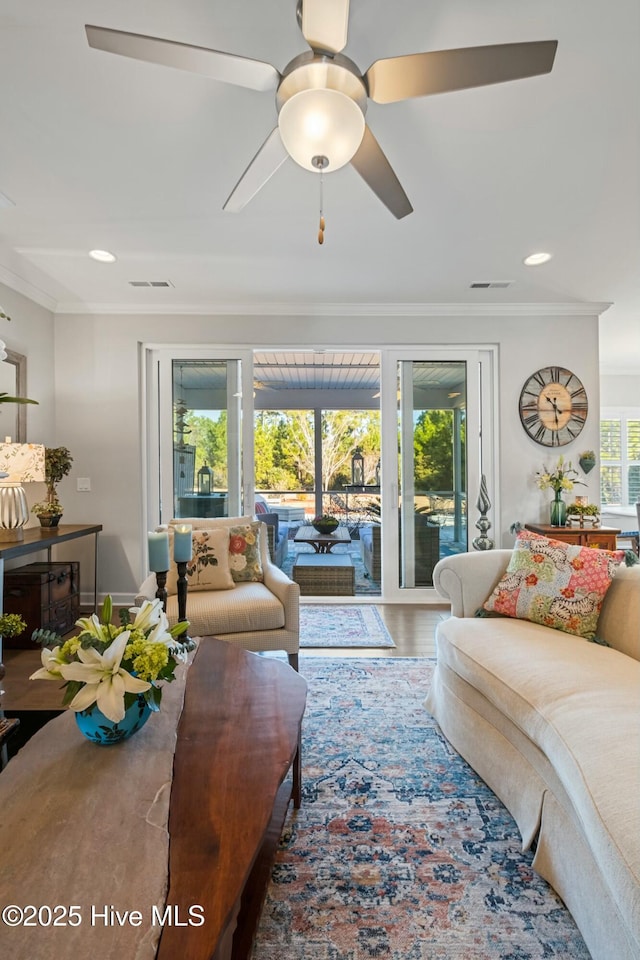 living room featuring ornamental molding, wood-type flooring, and ceiling fan