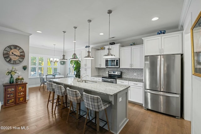 kitchen featuring sink, a breakfast bar area, a center island with sink, appliances with stainless steel finishes, and white cabinets