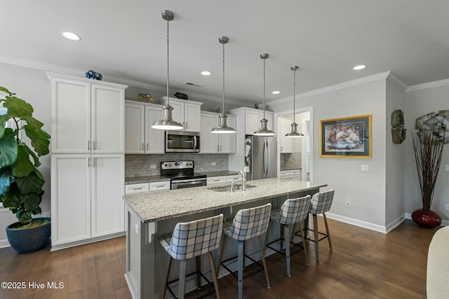 kitchen with an island with sink, white cabinetry, sink, a kitchen breakfast bar, and stainless steel appliances