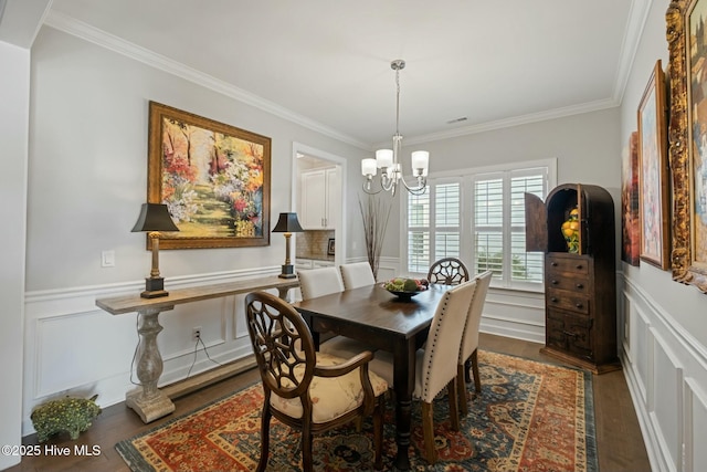 dining space with an inviting chandelier, ornamental molding, and dark hardwood / wood-style floors