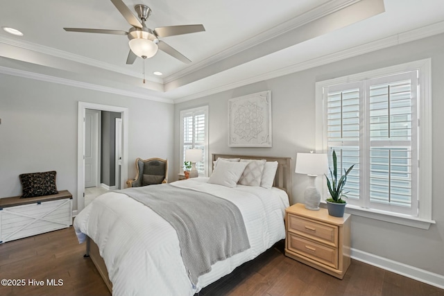 bedroom with dark wood-type flooring, ceiling fan, ornamental molding, and a raised ceiling