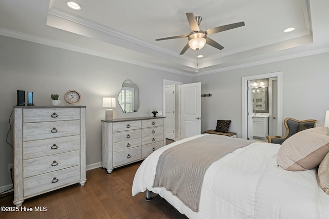 bedroom with ensuite bath, ornamental molding, a tray ceiling, and dark hardwood / wood-style flooring