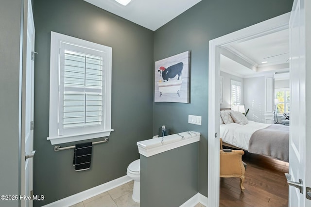 bathroom with ornamental molding, wood-type flooring, and toilet