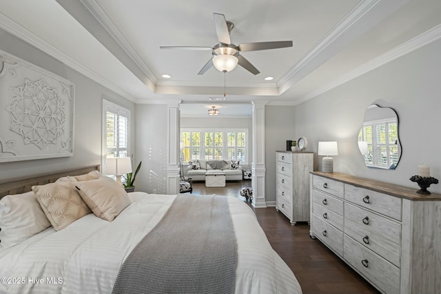 bedroom with ornamental molding, dark hardwood / wood-style floors, a raised ceiling, ceiling fan, and decorative columns