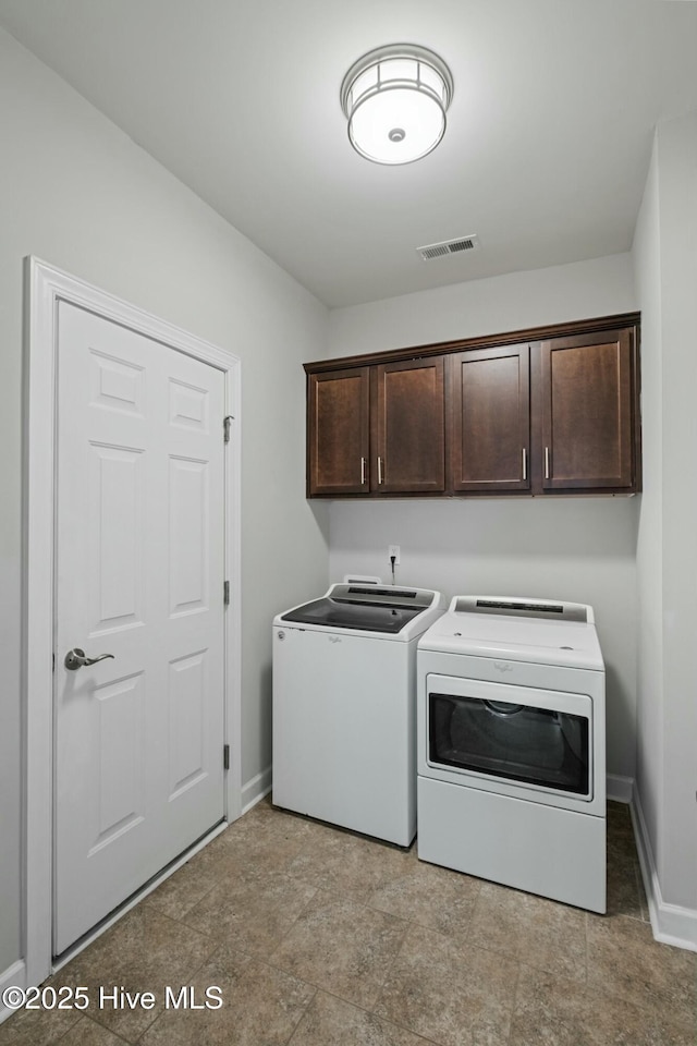 laundry room featuring cabinets and washer and dryer