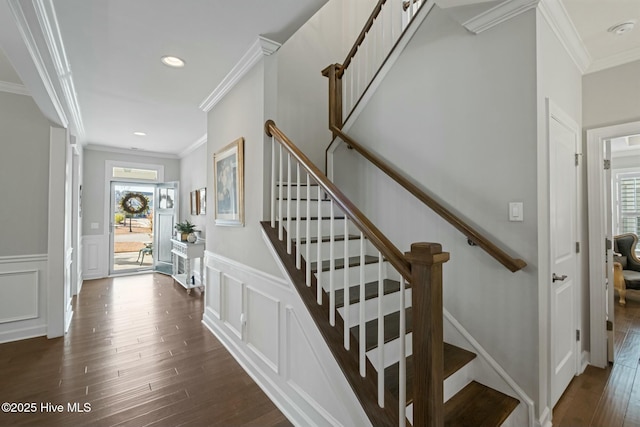 staircase with wood-type flooring and crown molding