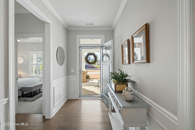 foyer entrance with crown molding and dark wood-type flooring