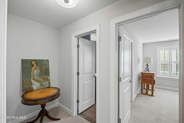 hall featuring dark colored carpet