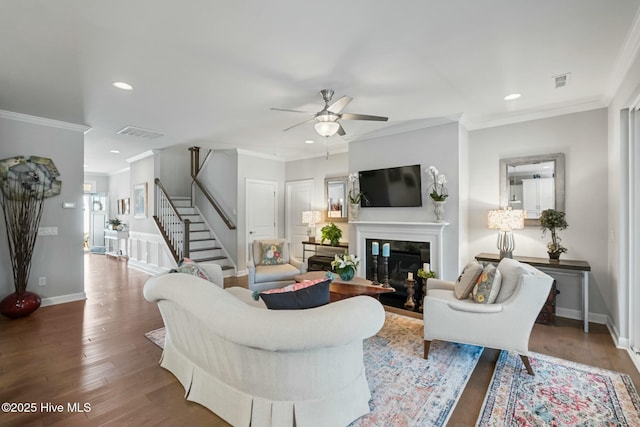 living room with ornamental molding, hardwood / wood-style floors, and ceiling fan