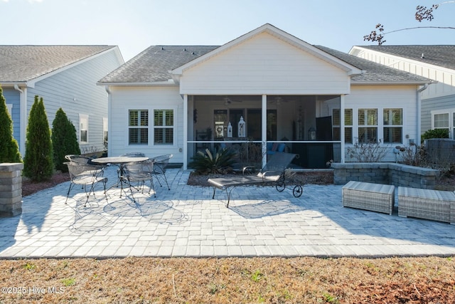 back of property with a sunroom, ceiling fan, and a patio area