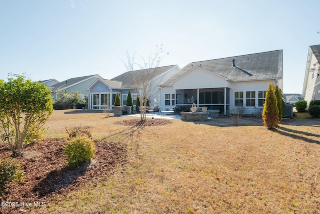 rear view of property with a sunroom, a patio, and a lawn