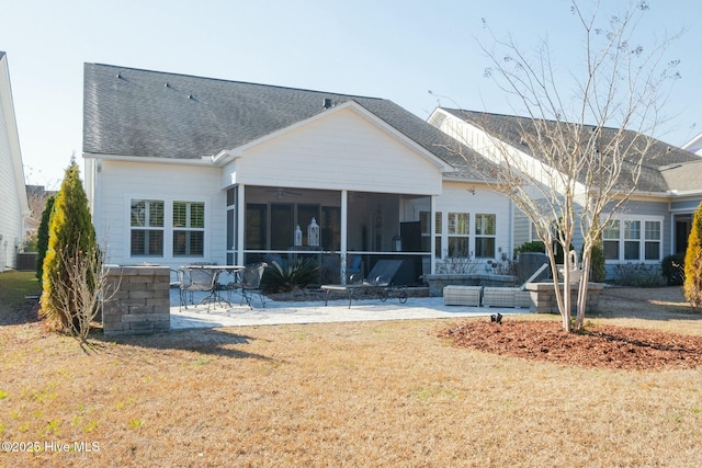 rear view of property featuring a sunroom, a lawn, central air condition unit, and a patio area