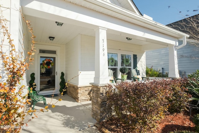 view of exterior entry featuring covered porch