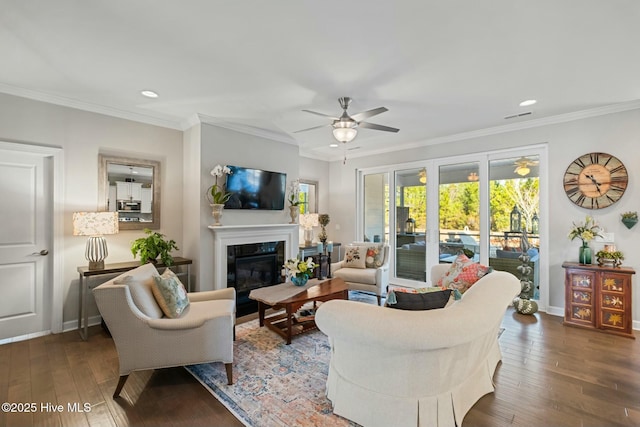 living room with ceiling fan, ornamental molding, a high end fireplace, and dark hardwood / wood-style flooring