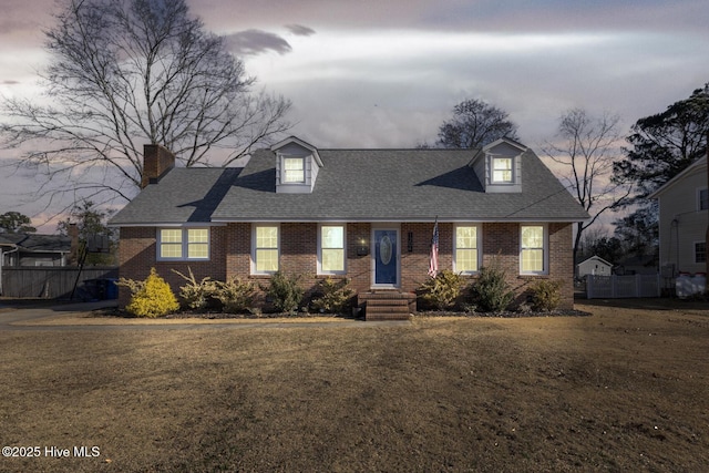 new england style home featuring a yard