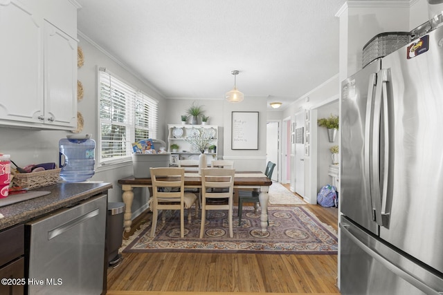 dining space featuring ornamental molding and hardwood / wood-style floors