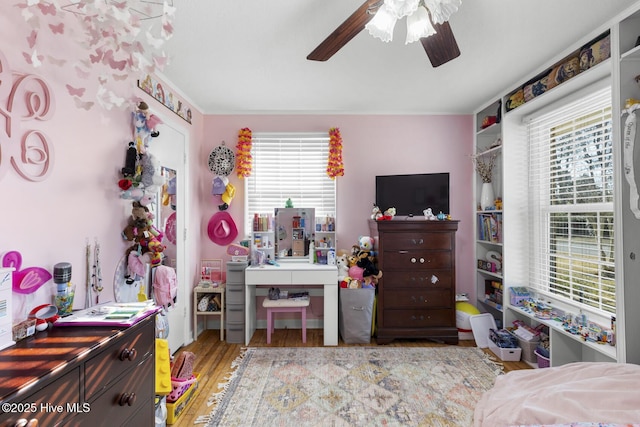 bedroom featuring ceiling fan, multiple windows, and wood-type flooring