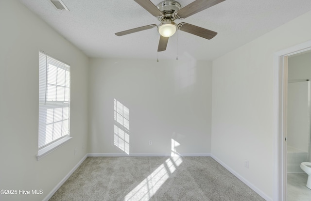 carpeted empty room featuring ceiling fan and a textured ceiling