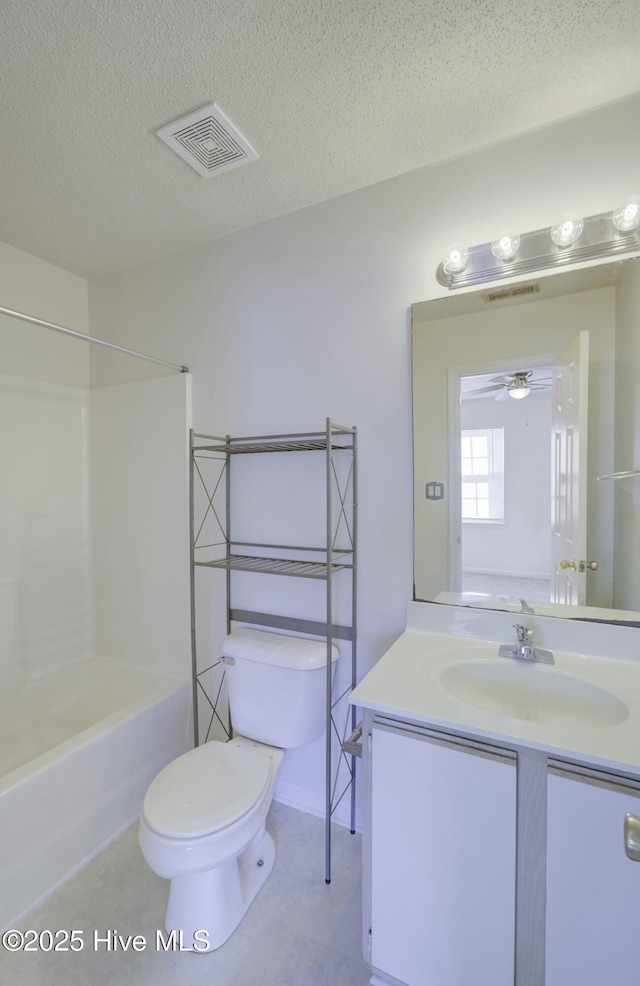 full bathroom featuring toilet, a textured ceiling, bathtub / shower combination, ceiling fan, and vanity