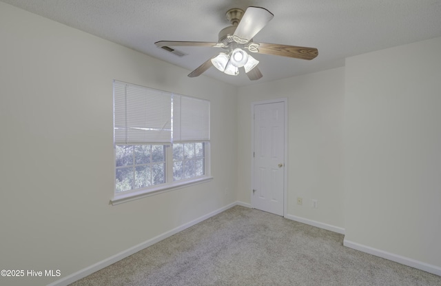 carpeted empty room featuring ceiling fan and a textured ceiling