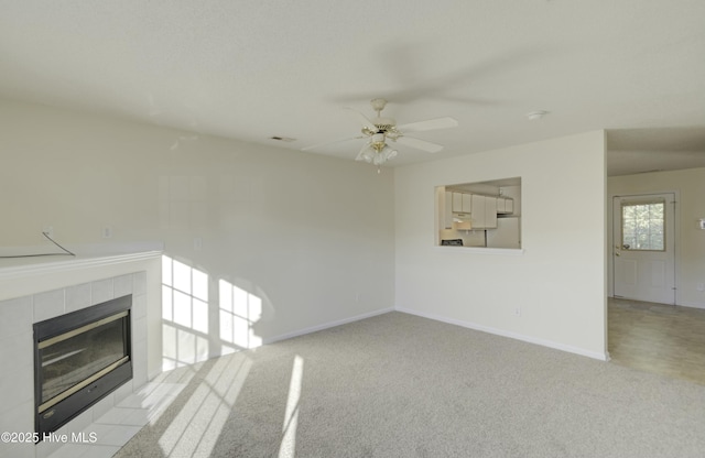 unfurnished living room with ceiling fan, light carpet, and a fireplace