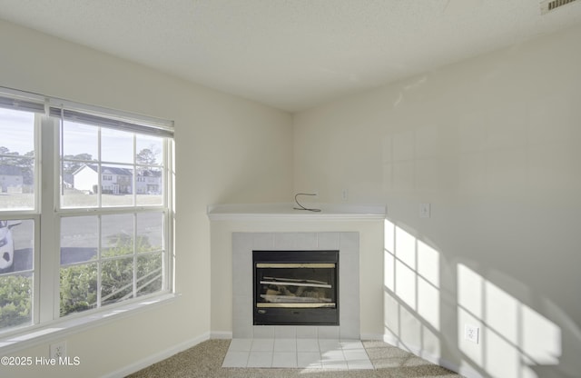 unfurnished living room with a fireplace, light colored carpet, and a textured ceiling