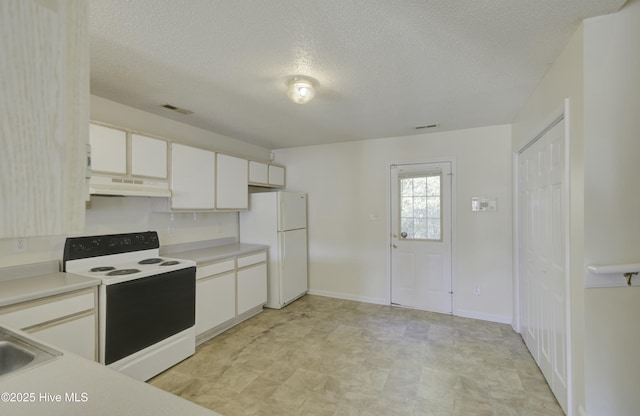 kitchen with electric range, white fridge, white cabinetry, and a textured ceiling