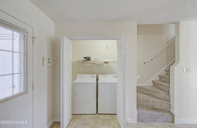 washroom featuring a textured ceiling and washing machine and clothes dryer