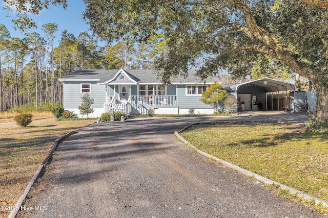 single story home featuring a front lawn, a carport, and a porch