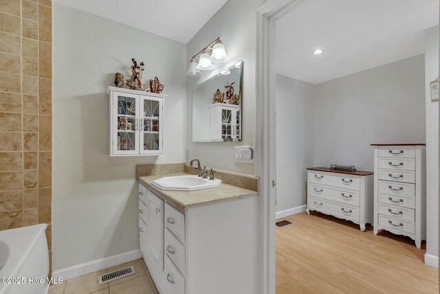 1126 Ccc Rd, Sneads Ferry, NC 28460 - bathroom featuring vanity, a washtub, and hardwood / wood-style floors